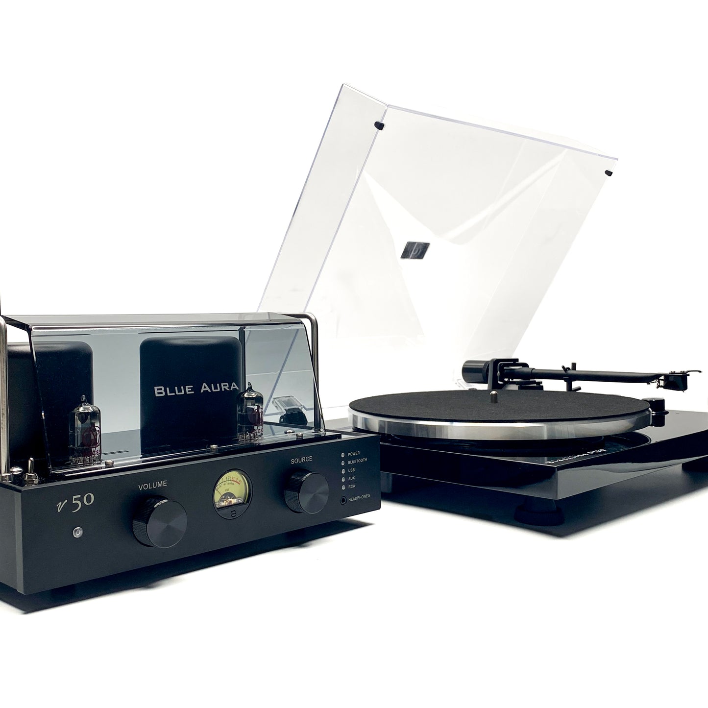 Three-quarter high-angle studio view of the Blue Aura Core System, showing the v50 hybrid amplifier with its red JJ Electronics tube logos and white branded plexiglas, next to the Blackline PG2 turntable with its clear dust cover opened.