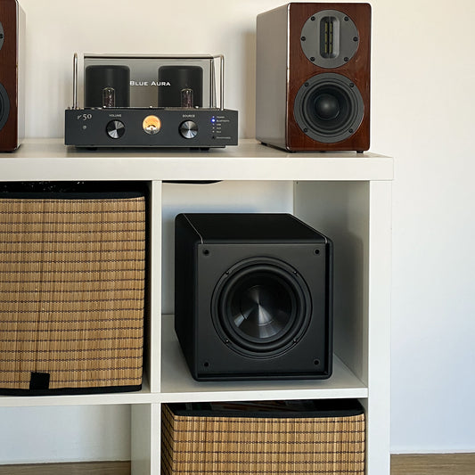 Blue Aura v50 hybrid amplifier and Walnut AT700 speakers with the X-Sub subwoofer arranged in a white bookshelf.