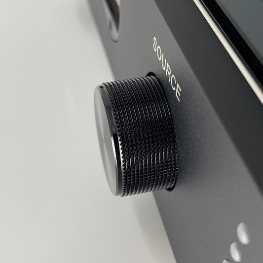 Official macro close-up view focusing on the knurled black aluminium source selector knob on the front panel of the Blue Aura v50 amplifier.