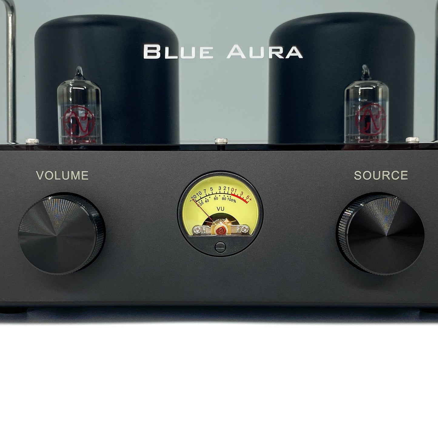 Official macro close-up front view of the Blue Aura v50 hybrid valve amplifier at rest, focusing on the circular yellow VU meter balanced between the dual black aluminium control knobs, with JJ Electronic ECC83 vacuum tubes visible behind.