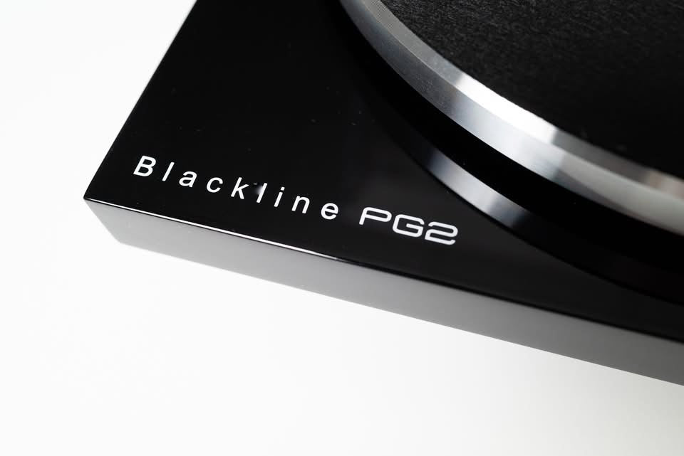 Macro close-up shot focusing on the elegant Blackline PG2 by Blue Aura branding printed on the corner of the glossy turntable plinth.