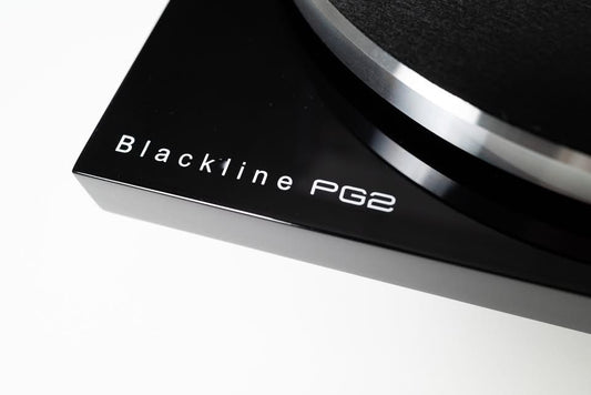 Macro close-up shot focusing on the elegant Blackline PG2 by Blue Aura branding printed on the corner of the glossy turntable plinth.