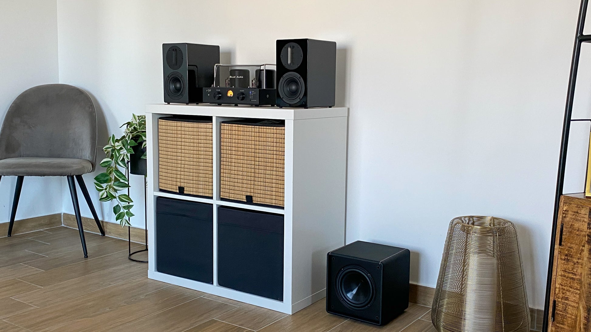 Blue Aura high-fidelity audio system with amplifier, speakers, and subwoofer in a living room.