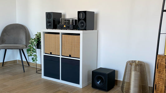 Blue Aura high-fidelity audio system with amplifier, speakers, and subwoofer in a living room.