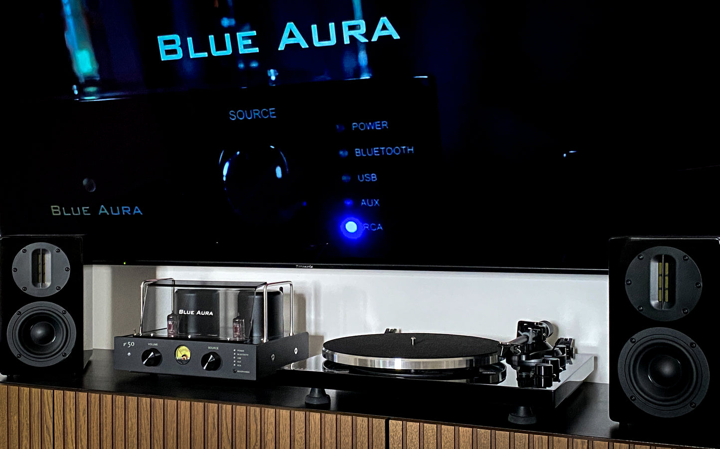 Ambient lifestyle view of the complete Blue Aura Soul System Black Hi-Fi setup on a TV cabinet, showing the turntable without its clear dust cover.