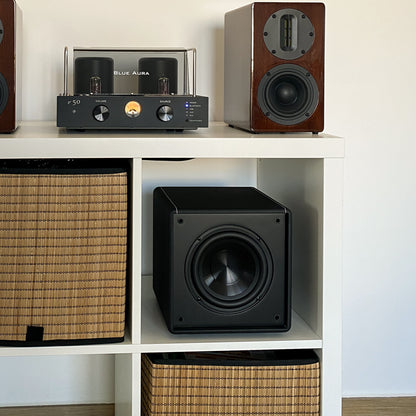 Blue Aura v50 hybrid amplifier and Walnut AT700 speakers with the X-Sub subwoofer arranged in a white bookshelf.