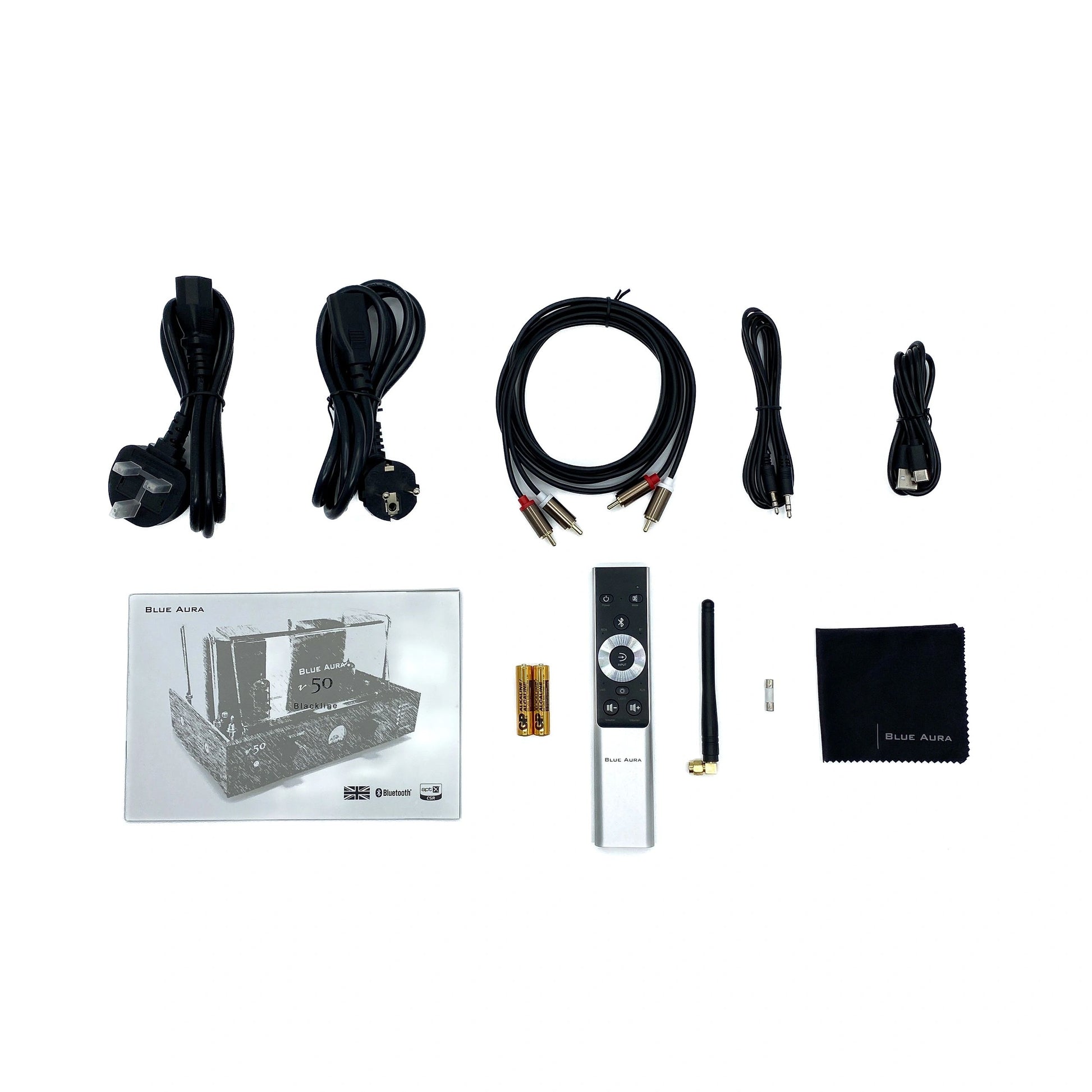 Flat lay studio view of the official setup items included with the Blue Aura v50 hybrid amplifier, featuring the user manual, brushed aluminium remote control, power cables, RCA cords, Bluetooth antenna, and microfibre cleaning cloth.