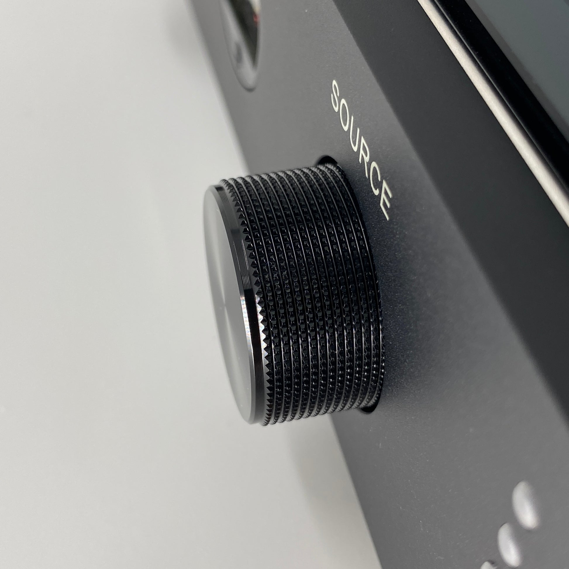 Official macro close-up view focusing on the knurled black aluminium source selector knob on the front panel of the Blue Aura v50 amplifier.
