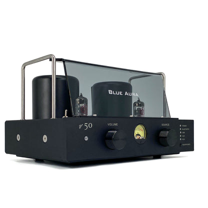 Official low-angle right three-quarter studio shot of the Blue Aura v50 hybrid valve amplifier at rest, showcasing its sleek front panel with dual black aluminium control knobs, circular VU meter, and protective plexiglas tube guard.