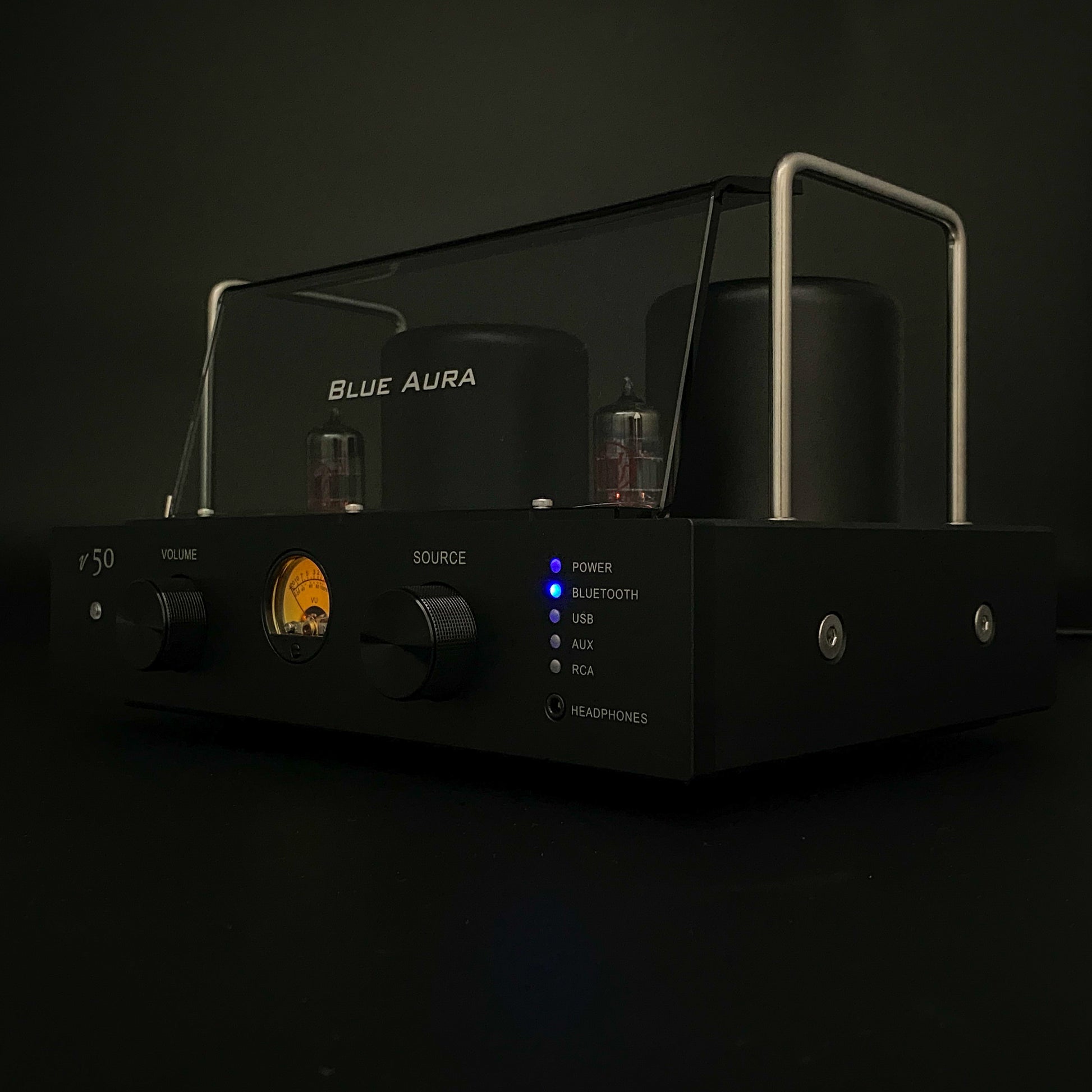 Studio shot of the Blue Aura v50 hybrid valve amplifier turned on against a black background.