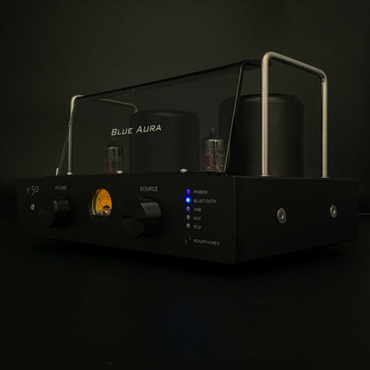 Studio shot of the Blue Aura v50 hybrid valve amplifier turned on against a black background.