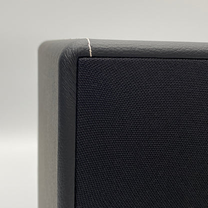 Official macro close-up view highlighting the premium stitching and textured black leatherette finish on the corner of the X-Sub subwoofer.