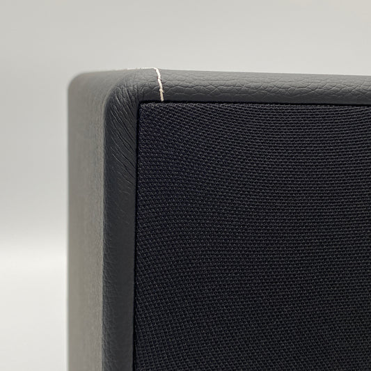 Official macro close-up view highlighting the premium stitching and textured black leatherette finish on the corner of the X-Sub subwoofer.